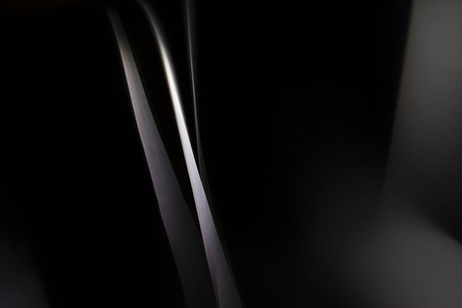 Fine beams of white light against darkness.