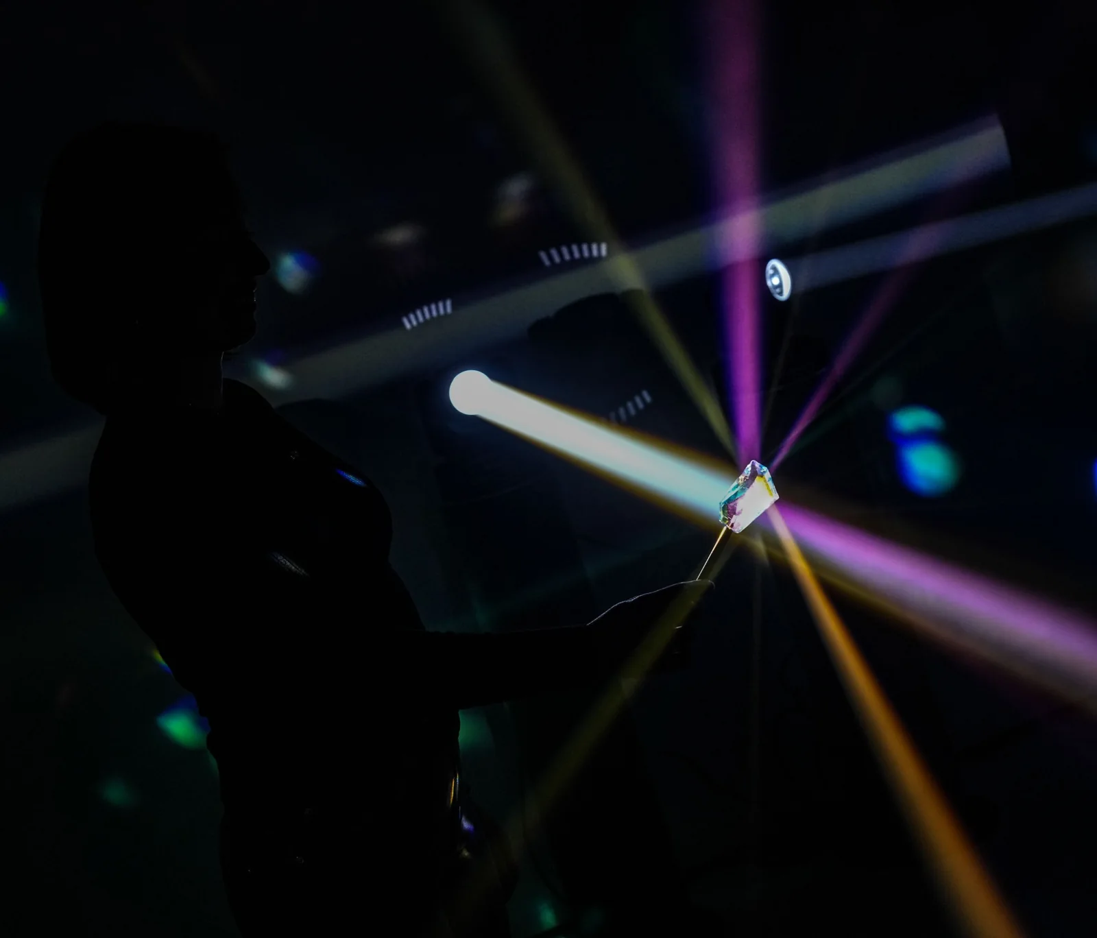 A visitor holds a prism in the violet and blue light.