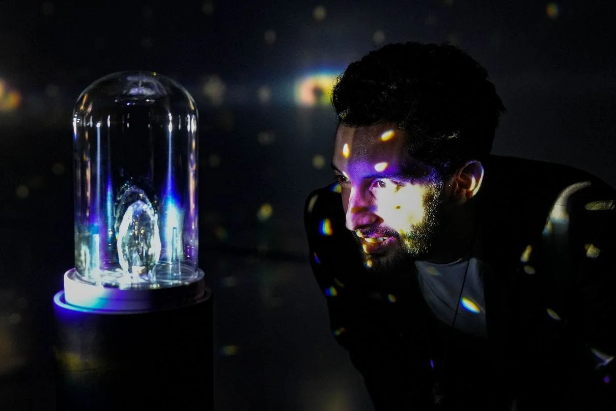 Raphaël looking into the illuminated prism installation.